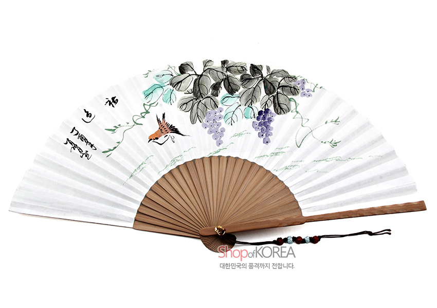 [텍스트: Shop of KOREA 대한민국의 품격까지 전합니다.] 대나무살 구조 위 흰 종이에 수묵채색으로 포도와 새, 덩굴을 정교하게 묘사하고 손잡이에 매듭 장식 술을 단 전통 합죽선 형태의 부채 모습