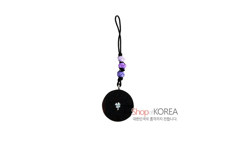[텍스트: Shop of KOREA 대한민국의 품격까지 전합니다.] 흑단 원형 장식에 자개로 표현한 작은 꽃문양과 보라색 전통매듭 장식이 어우러진 핸드폰고리