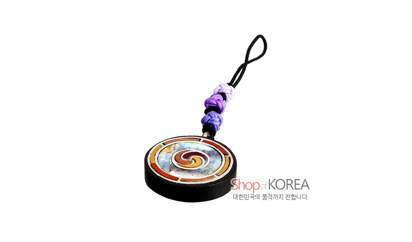 [텍스트: Shop of KOREA, 대한민국의 품격까지 전합니다.] 흑단 원형 바탕에 자개와 칼라 에나멜로 삼태극 문양을 상감하고 보라색 실을 엮은 매듭끈이 연결된 전통 열쇠고리형 장식
