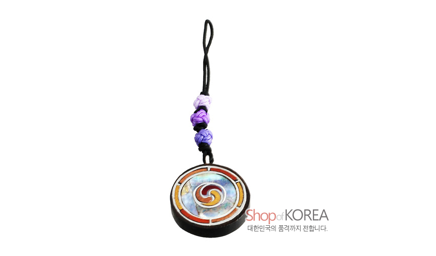 [텍스트: Shop of KOREA 대한민국의 품격까지 전합니다.] 흑단 원형 장식에 자개와 칼라 에나멜로 삼태극 문양을 넣고 보라색 매듭 비단끈을 연결한 전통 열쇠고리 디자인