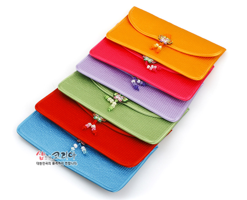 [텍스트: 샵오브코리아 대한민국의 품격까지 전합니다.] 다양한 색상의 누비 원단으로 제작된 장지갑, 앞면에 금속 장식과 실로 엮은 나비 매듭 및 구슬 장식이 더해진 전통 누비 지갑 디자인