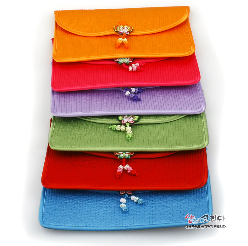 [텍스트: 샵오브코리아 대한민국의 품격까지 전합니다.] 오방색 계열 실크 누비 원단으로 제작된 직사각형 장지갑들, 앞면 중앙 전통 나비매듭과 매듭술 장식이 더해진 단색 세로누빔 디자인