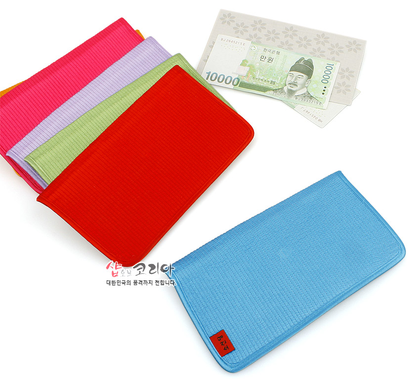 [텍스트: 샵오브코리아 대한민국의 품격까지 전합니다.] 붉은색·하늘색·분홍색·연두색 등 다양한 색상의 세로누빔 원단으로 제작된 장지갑과 만원권 지폐가 함께 배치된 이미지