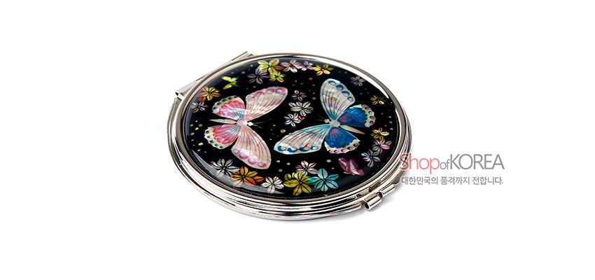 [텍스트: Shop of KOREA 대한민국의 품격까지 전합니다.] 흑색 바탕 위 자개 상감 기법으로 표현된 화려한 나비와 꽃 문양이 돋보이는 원형 금속 손거울 디자인