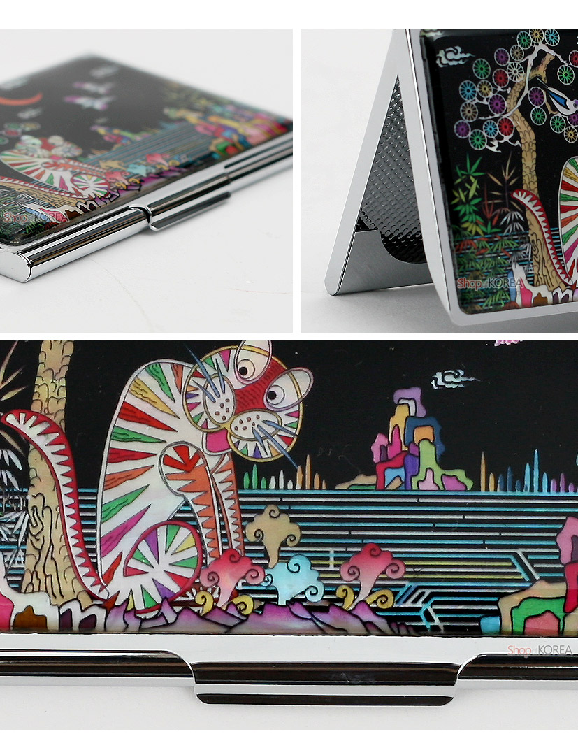 [텍스트: Shop KOREA] 흑색 바탕 금속 명함케이스 위에 자개 상감 기법으로 추상적 호랑이와 나무, 산수 풍경을 다채로운 색감으로 표현한 디자인