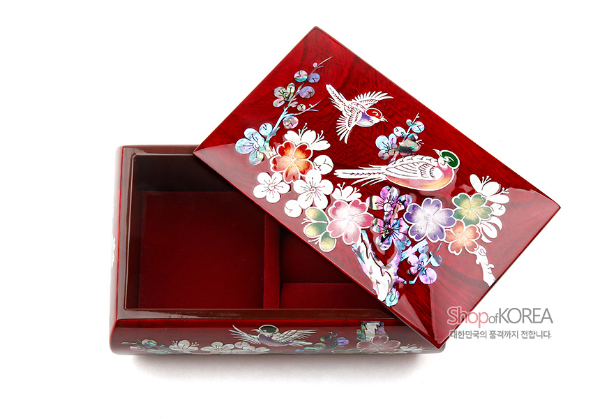 [텍스트: ShopofKOREA 대한민국의 품격까지 전합니다.] 붉은 옻칠 나무 위 자개 상감 기법으로 매화와 새, 꽃문양을 화려하게 장식한 반지꽂이 상자 내부 칸막이 구조 모습