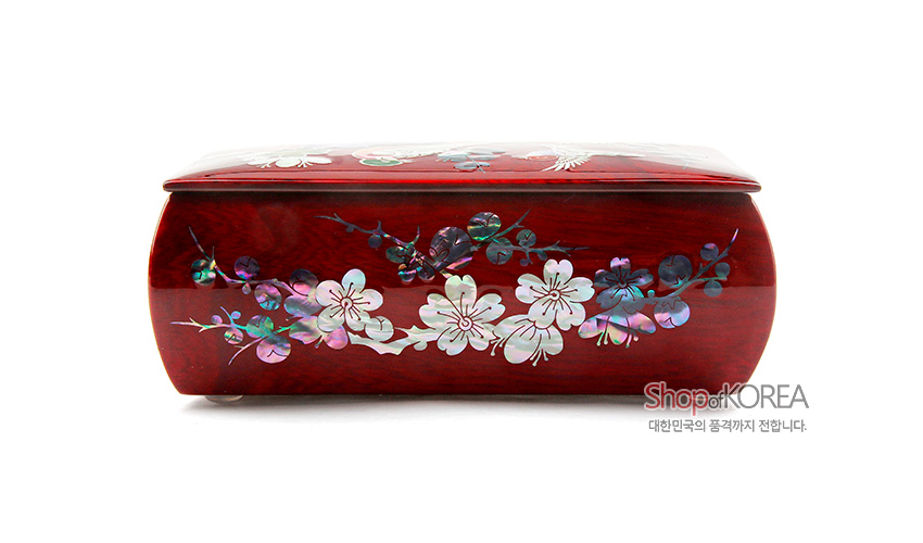 [텍스트: Shop of KOREA 대한민국의 품격까지 전합니다.] 붉은 옻칠 나무 표면에 자개 상감 기법으로 매화와 꽃문양을 섬세하게 장식한 곡선형 반지꽂이 함