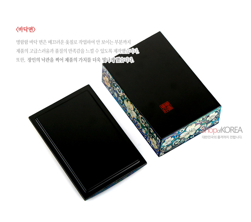 [텍스트: <바닥면> 명함함 바닥 면은 매끄러운 옻칠로 작업하여 안 보이는 부분까지 제품의 고급스러움과 품질의 만족감을 느낄 수 있도록 제작했습니다. 또한, 장인의 낙관을 찍어 제품의 가치를 더욱 빛나게 했습니다. Shop of KOREA 대한민국의 품격까지 전합니다.] 흑색 옻칠 바탕 위 붉은 낙관과 측면 자개 상감 목단·넝쿨무늬 장식 직사각 명함함 이미지