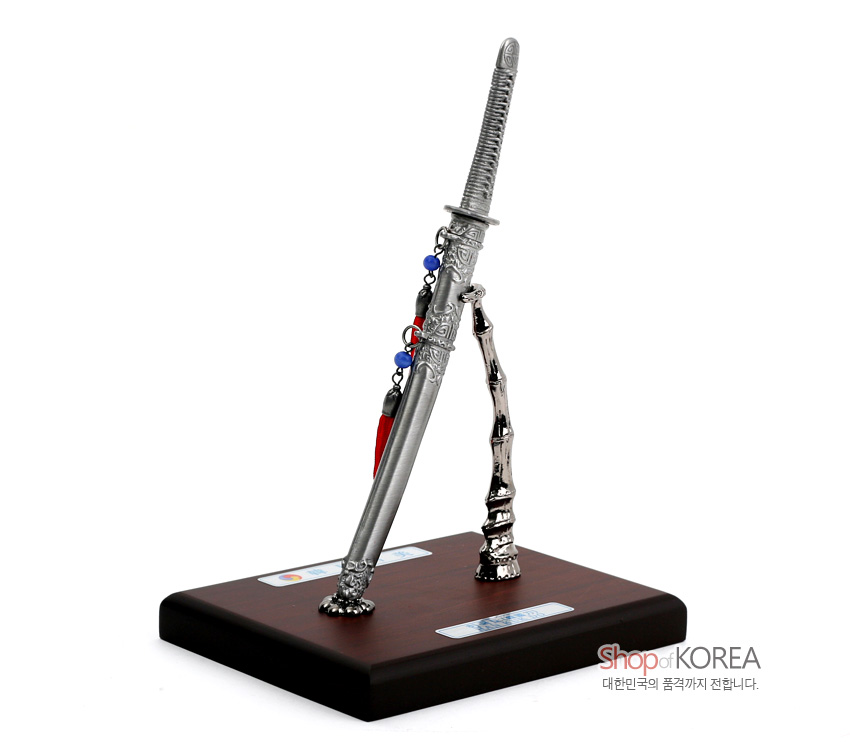 [텍스트: Shop of KOREA 대한민국의 품격까지 전합니다.] 금속 주석 재질 한국도 모형과 대나무 형상 은빛 스탠드, 적·청색 구슬 매듭 장식, 나무 받침대 구성 장식품