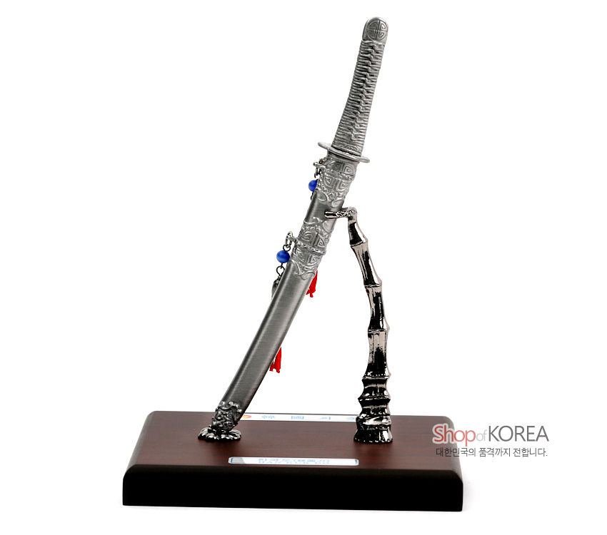 [텍스트: Shop of KOREA 대한민국의 품격까지 전합니다.] 금속 주조 한국도 모형과 대나무 형상 스탠드, 적색 술매듭과 청색 구슬 장식이 얹힌 목제 받침 장식품