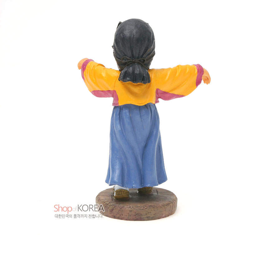 [텍스트: Shop of KOREA 대한민국의 품격까지 전합니다.] 채색 수지로 표현한 부네탈 인형의 후면, 노란 저고리와 파란 치마, 나무纹 받침대 조합의 전통 복식 조형 표현