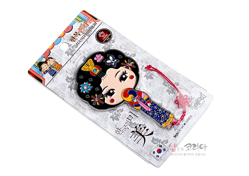 [텍스트: 한복손거울 HAND MIRROR / 한국의 미 美 / MADE IN KOREA] 금속 재질과 컬러 에나멜 기법으로 표현한 황진이 한복 캐릭터, 오방색 한복과 꽃·나비 문양 장식, 붉은 전통 매듭 끈 구성
