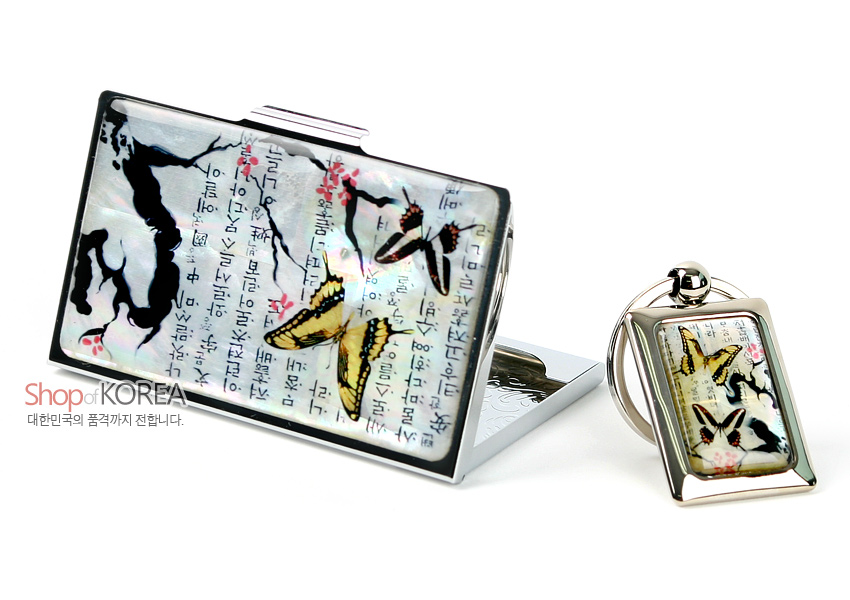 [텍스트: Shop of KOREA 대한민국의 꿈과까지 전합니다.] 자개 바탕 위 한글 서체를 상감하고 매화 가지와 나비를 세밀 채색한 은빛 금속 명함집과 열쇠고리 세트 모습