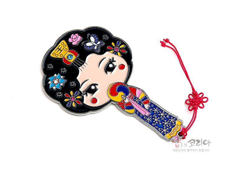 [텍스트: KOREA] 금속 재질에 컬러 에나멜 기법으로 표현된 황진이 캐릭터 손거울, 꽃과 나비 문양, 오방색 한복과 붉은 전통 매듭 끈 장식 특징의 디자인