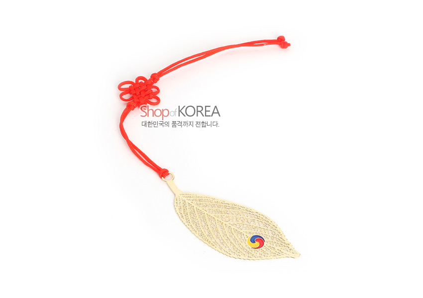 [텍스트: Shop of KOREA / 대한민국의 품격까지 전합니다.] 금속 재질 금장 나뭇잎 모양 책갈피, 섬세한 잎맥 레이저 컷 문양과 삼색 태극 문양 장식, 붉은 전통 매듭 끈 포인트 디자인