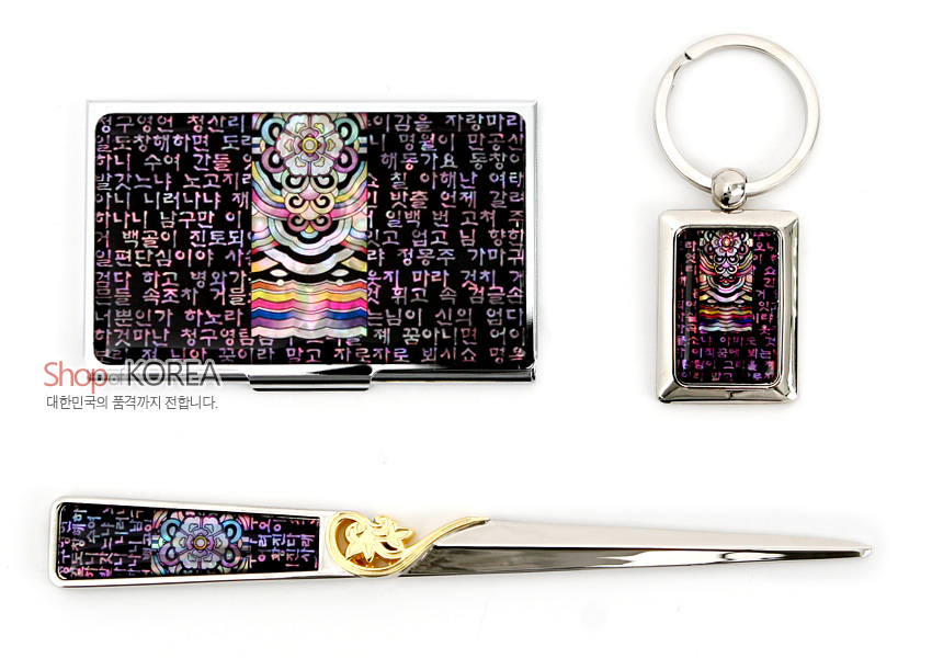 [텍스트: Shop KOREA 대한민국의 품격까지 전합니다.] 흑자 바탕 위 시조 한글 문자와 자개 단청문양이 상감된 금속 명함집·열쇠고리·편지칼 3종 세트, 보라·오방색의 은은한 광택이 돋보이는 디자인