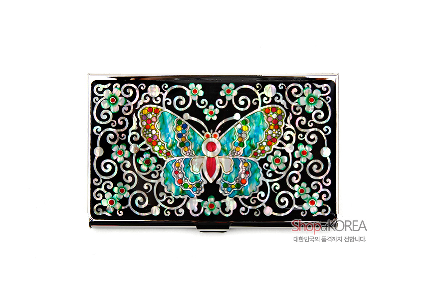 [텍스트: ShopKOREA 대한민국의 품격까지 전합니다.] 흑색 바탕 위 자개 상감 기법으로 표현된 다채로운 채색 나비와 꽃덩굴 문양 금속 명함케이스 이미지 설명