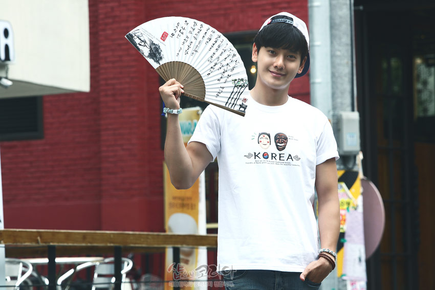 [텍스트: KOREA] 흰색 면 티셔츠 전면에 하회탈 문양과 영문 레터링, 장식적인 선형 패턴이 입체발포 기법으로 표현된 모습