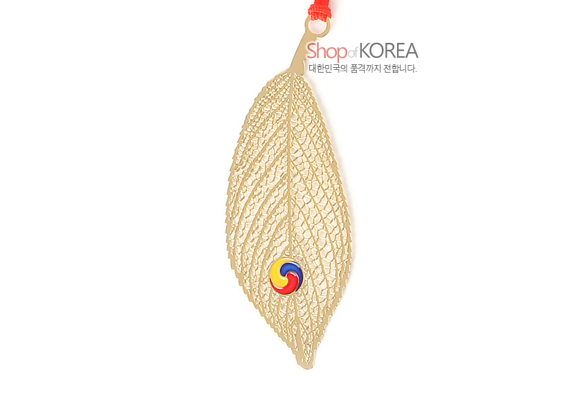 [텍스트: Shop of KOREA / 대한민국의 품격까지 전합니다.] 금속 재질 금장 나뭇잎 형태 책갈피, 섬세한 잎맥 레이저 컷 문양과 삼색 태극 문양 장식, 붉은 매듭 끈 장식 이미지 설명