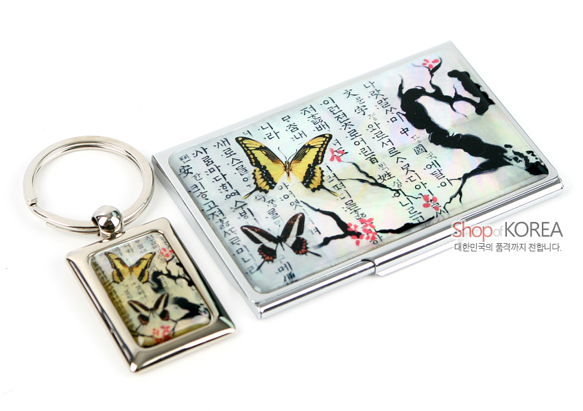 [텍스트: Shop of KOREA, 대한민국의 품격까지 전합니다.] 자개 바탕에 한글 서체와 매화 가지, 노랑·갈색 나비 문양을 담은 금속 명함집과 직사각 메탈 키홀더 세트 디자인