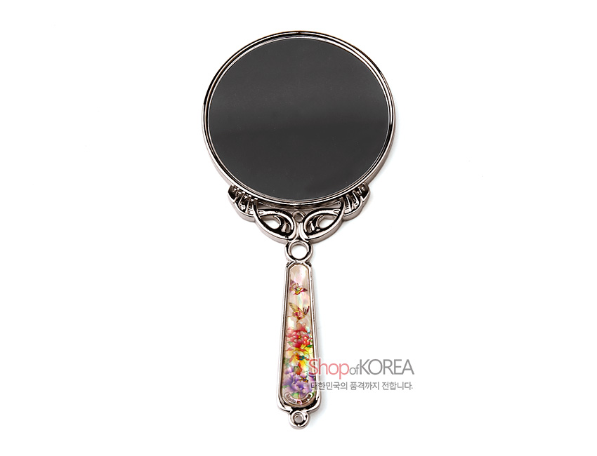 [텍스트: Shop of KOREA 대한민국의 품격까지 전합니다.] 금속 손잡이 위 자개 상감 기법으로 다채로운 목단꽃과 나비 문양을 표현한 원형 손거울 이미지 설명