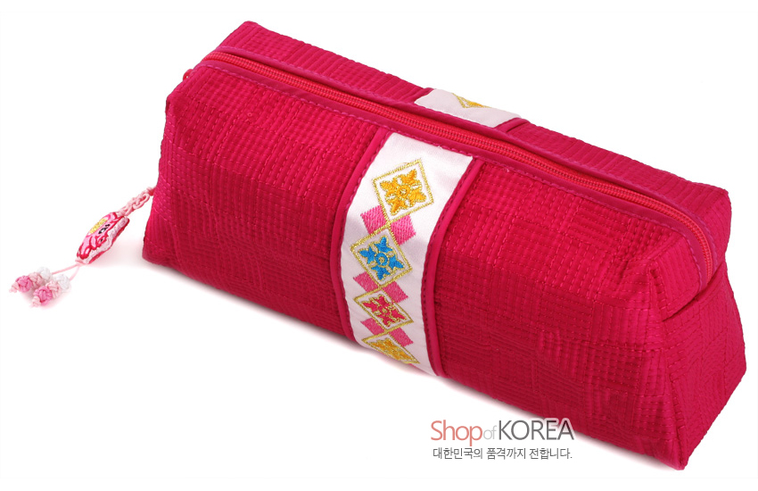[텍스트: Shop of KOREA 대한민국의 품격까지 전합니다] 선명한 적색 누비 비단으로 만든 필통, 중앙 흰색 띠 위 기하학 자수 문양과 복돼지 매듭 장식이 돋보이는 디자인