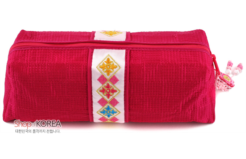 [텍스트: Shop of KOREA 대한민국의 품격까지 전합니다.] 선명한 적색 누비 비단으로 제작된 필통, 중앙 흰색 띠 위 금사 기하학 자수와 측면 복돼지 매듭 장식 특징