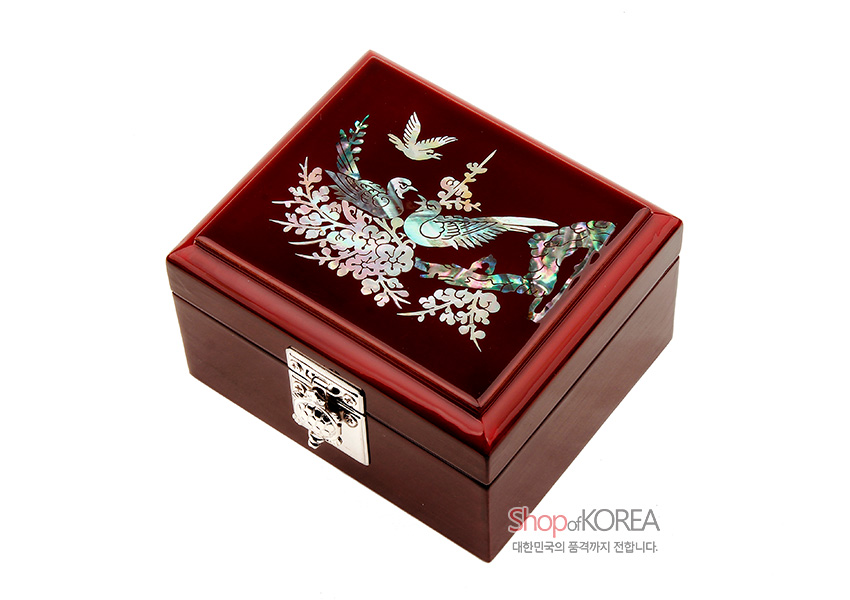 [텍스트: Shop of KOREA, 대한민국의 품격까지 전합니다.] 붉은 옻칠 표면 위 자개 상감으로 매화와 새 문양을 넣고 은색 금속 잠금장식을 더한 사각 보석함 디자인