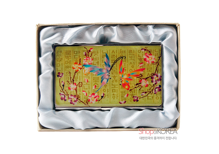 [텍스트: ShopofKOREA 대한민국의 품격까지 전합니다.] 황금빛 훈민정음 배경 위 자개 상감 나비와 매화 가지 문양이 어우러진 금속 명함집, 실크 안감 포장 모습