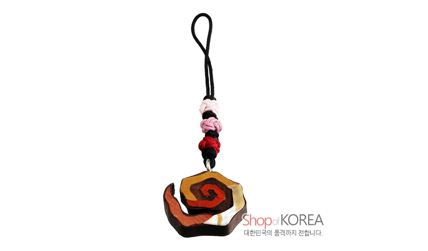 [텍스트: Shop of KOREA 대한민국의 품격까지 전합니다.] 흑단과 천연목을 조합한 나선 장미불 문양 열쇠고리, 적·황·백 색 대비와 흑색 끈, 적·분홍 매듭 장식이 어우러진 전통 느낌의 소품