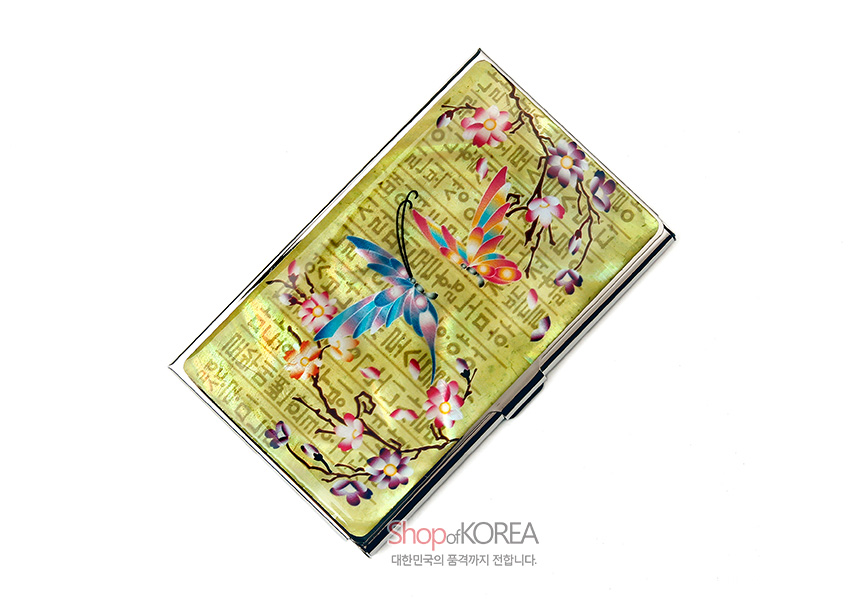 [텍스트: Shop of KOREA 대한민국의 품격까지 전합니다.] 황금빛 금속 바탕 위 자개 상감 나비와 매화 가지 문양, 훈민정음 글자 배경이 조화된 명함집 디자인