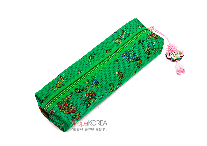 [텍스트: ShopofKOREA 대한민국의 품격까지 전합니다.] 녹색 누비 원단 위 금색 꽃과 잎 전통문양, 지퍼 손잡이의 분홍 나비 매듭 장식이 조화를 이루는 직사각형 필통 이미지 설명