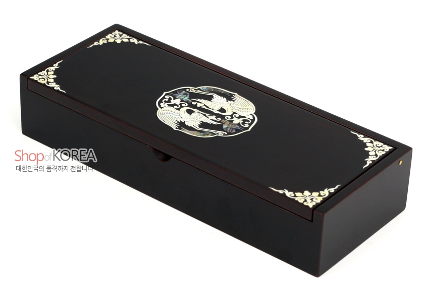 [텍스트: ShopofKOREA, 대한민국의 품격까지 전합니다.] 짙은 흑색 옻칠 바탕에 자개 상감 기법으로 원형 쌍학 문양과 모서리 연화문을 장식한 직사각 나전 자동필함 이미지 설명