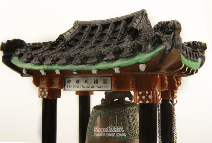 [텍스트: 韓國의鐘閣 / The Bell House of Korean / Shop of KOREA] 청동 색감 종과 흑색 기와지붕, 녹색 단청 표현 기둥이 조화를 이룬 전통 종각 미니어처 장식품
