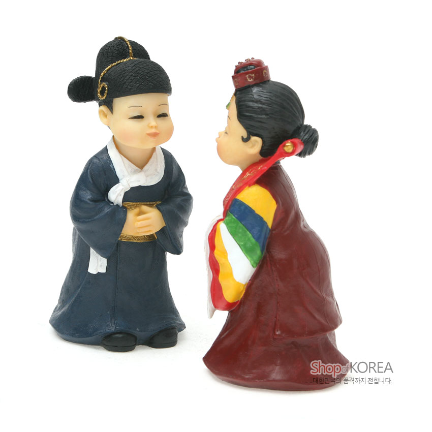 [텍스트: Shop of KOREA 대한민국의 품격까지 전합니다.] 레진 소재로 구현한 전통혼례 신랑신부 인형, 남색 도포와 금색 띠, 오방색 색동 소매와 붉은 활옷, 족두리 장식 표현