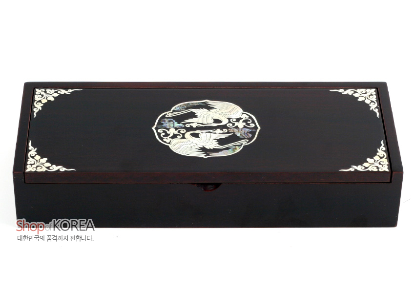[텍스트: Shop of KOREA 대한민국의 품격까지 전합니다.] 짙은 흑색 옻칠 나무 위 자개 상감 기법으로 쌍학 원형 문양과 모서리 연화문을 장식한 직사각 자동필함 모습