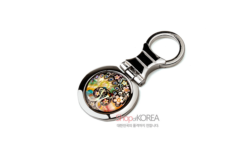 [텍스트: Shop of KOREA / 대한민국의 품격까지 전합니다.] 자개 상감 기법으로 공작과 꽃 문양을 표현한 오색 자개 장식 금속 손거울 형태 키링 디자인
