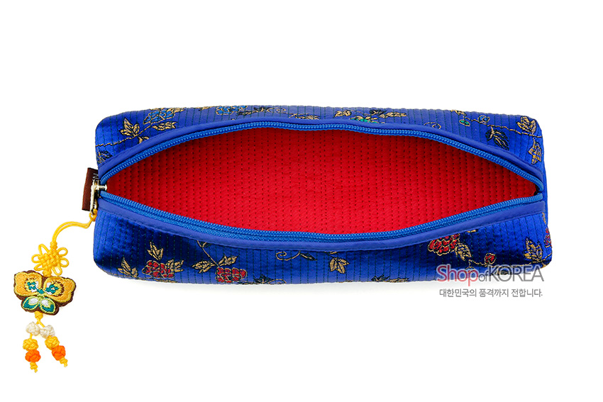 [텍스트: Shop of KOREA 대한민국의 품격까지 전합니다.] 청색 누비 비단에 금색·빨간색 꽃과 덩굴 문양 자수, 붉은 안감과 노란 나비 매듭 장식 지퍼의 필통 모습