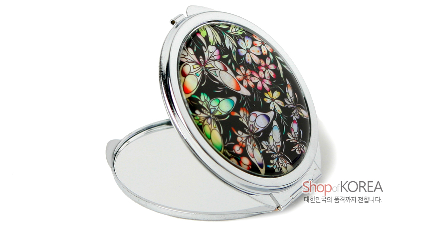 [텍스트: Shop of KOREA 대한민국의 품격까지 전합니다.] 검은 바탕에 자개 상감 기법으로 다채로운 나비와 꽃문양을 넣은 원형 금속 손거울, 은색 프레임과 이중 접이식 거울 구조 표현