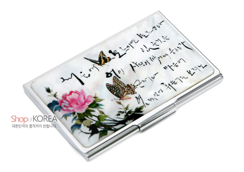 [텍스트: Shop of KOREA 대한민국의 품격까지 전합니다.] 자개 바탕 위 분홍 모란과 나비, 흑색 한글 시조 서체가 어우러진 상감 기법 금속 명함집 디자인