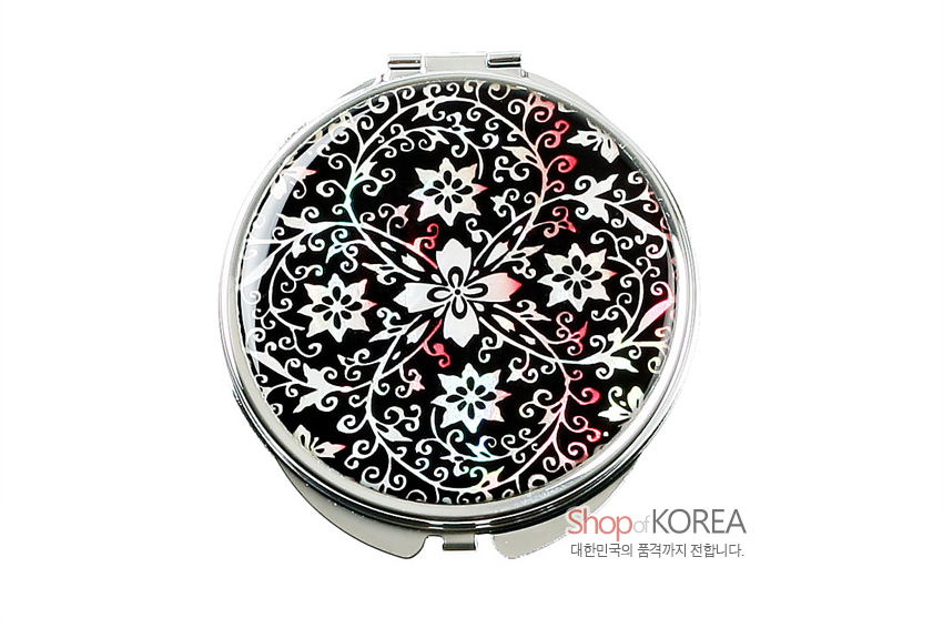 [텍스트: Shop of KOREA 대한민국의 품격까지 전합니다.] 검은 바탕 위 자개 상감으로 흰색·분홍빛 당초문과 꽃문양을 장식한 원형 금속 손거울 디자인