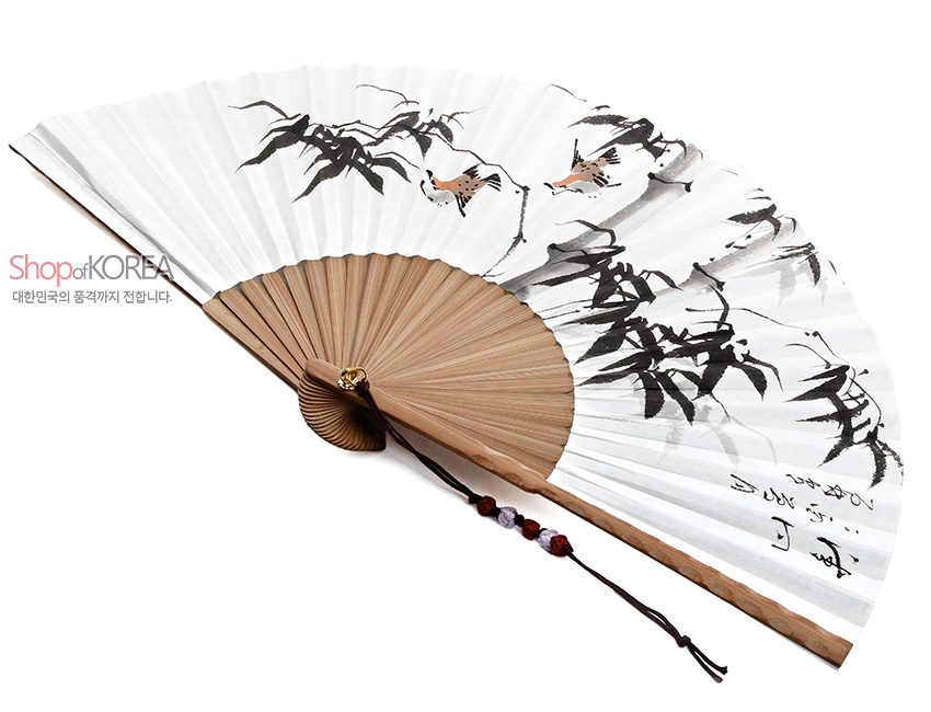 [텍스트: Shop of KOREA 대한민국의 품격까지 전합니다.] 대나무살 구조 위 흰 종이 면에 수묵 담채로 대나무와 새, 한글 서예가 그려지고 옥잔형 매듭과 구슬 장식 술이 더해진 전통 접이식 부채 이미지 설명