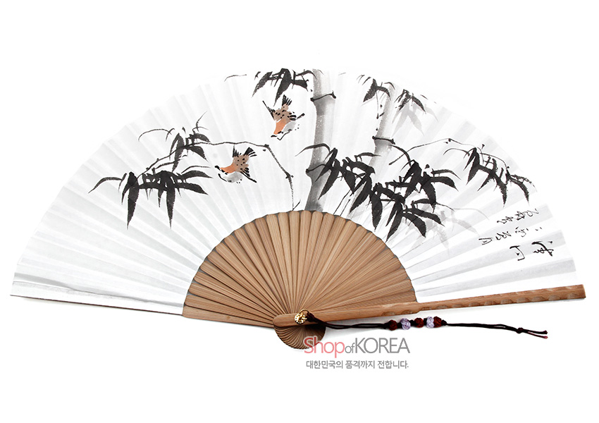 [텍스트: shop of KOREA / 대한민국의 품격까지 전합니다.] 대나무 살 위 흰 한지에 수묵채색으로 대나무와 새, 한글 서예를 담고 매듭 장식 술을 단 전통 부채 이미지 설명