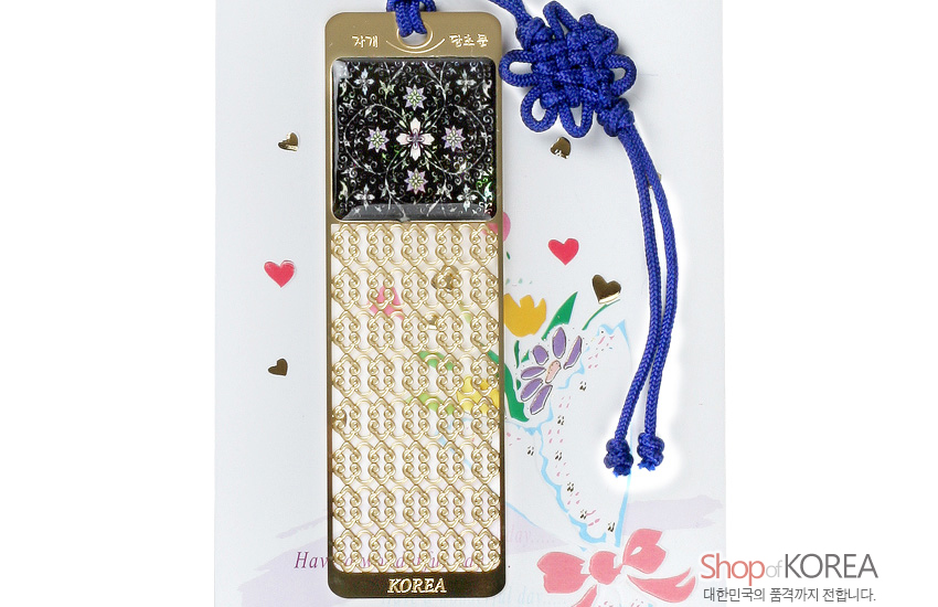 [텍스트: 자개, 당초문, KOREA] 금속 바탕 위 자개 상감 꽃문양과 금빛 당초무늬 장식, 청색 전통 매듭 끈 포인트 디자인