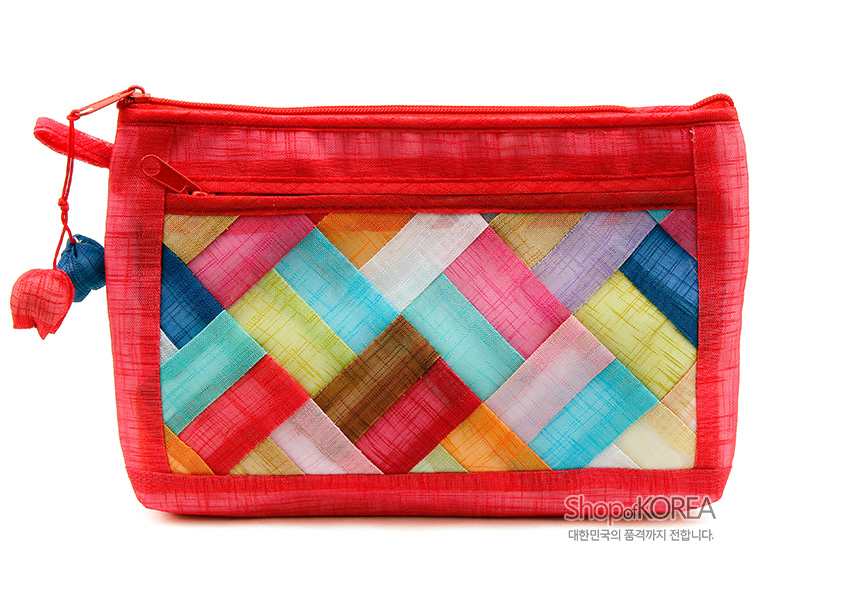 [텍스트: Shop of KOREA, 대한민국의 품격까지 전합니다.] 붉은 모시 바탕에 다채로운 색의 조각보 누비 패턴과 실타래 매듭 장식이 어우러진 직사각형 파우치 디자인