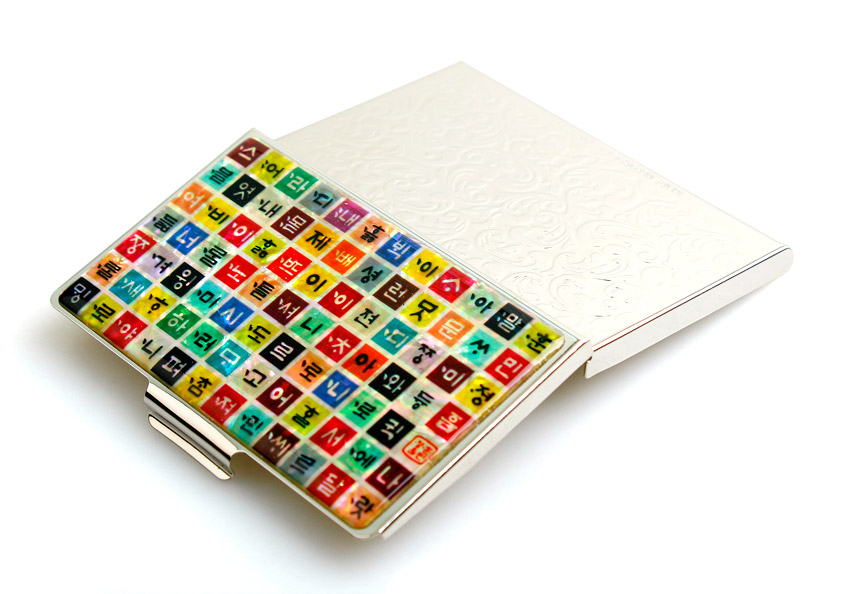 [텍스트: 한,글,훈,민,정,음 등 한글 자모] 금속 재질 위에 자개 느낌의 다채로운 색상 정사각형 칸마다 한글 자모를 배열하고, 뒷면에는 은빛 음각무늬를 새긴 명함집 디자인