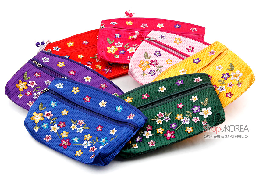 [텍스트: Shop of KOREA 대한민국의 품격까지 전합니다.] 누비 기법의 원단 위에 다채로운 배꽃과 잎사귀 자수를 놓고 매듭 장식 지퍼 손잡이를 더한 다색 꽃무늬 파우치들 모습