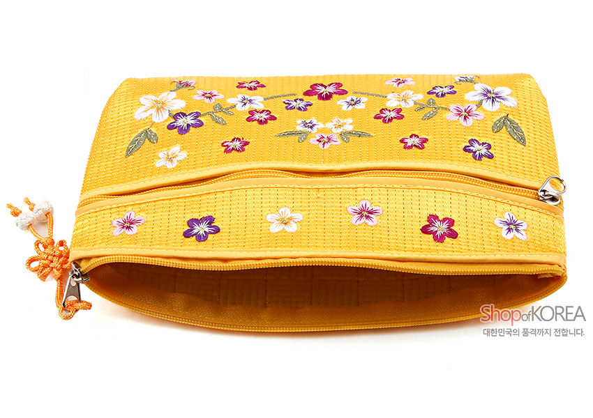 [텍스트: Shop of KOREA 대한민국의 품격까지 전합니다.] 노란 누비 원단 위 다채로운 배꽃 자수와 잎사귀 문양, 매듭 장식 지퍼 손잡이가 돋보이는 파우치 디자인