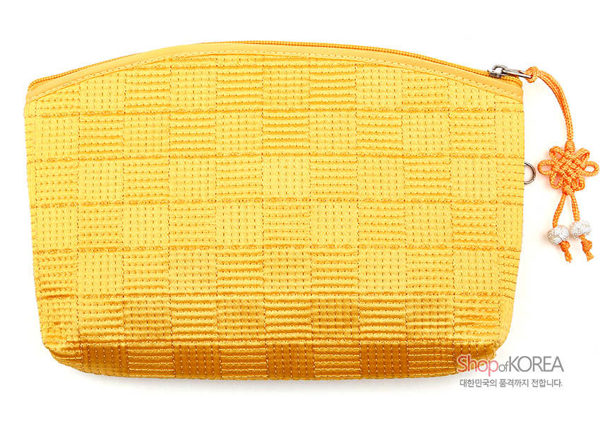 [텍스트: Shop of KOREA 대한민국의 품격까지 전합니다.] 노란색 직조 누비 원단의 격자 무늬 파우치와 배꽃 매듭 장식 지퍼 손잡이 디테일 표현