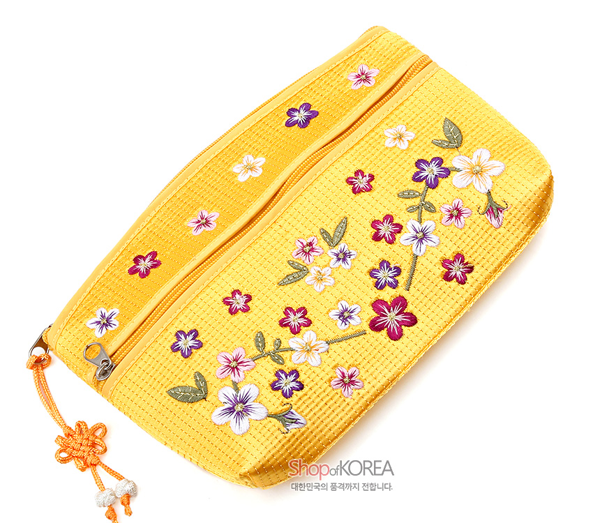[텍스트: Shop of KOREA 대한민국의 품격까지 전합니다.] 노란색 직조 누비 원단 위 다채로운 배꽃과 잎사귀 자수, 매듭 장식 지퍼 손잡이가 조화를 이룬 파우치 디자인